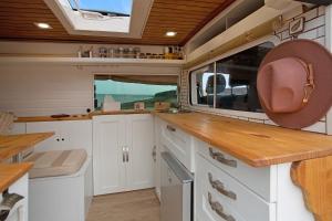 a kitchen with white cabinets and a large window at Inikcamper in Ingenio