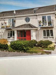 a house with a red door on a street at Oranmore Apartment on the Wild Atlantic Way in Oranmore