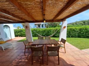 een houten tafel en stoelen op een patio bij Villa Xalina - Piscina / bbq / jardín in Fornells