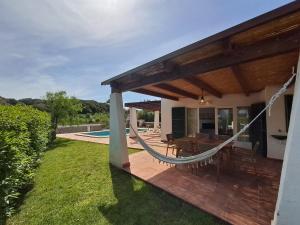 a patio with a hammock on a house at Villa Xalina - Piscina / bbq / jardín in Fornells