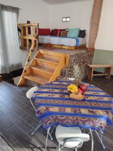 a room with a table and a bed with a table sidx sidx at Cabañas Rica-Rica Lodge in San Pedro de Atacama