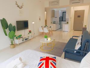 Rooftop Pool, Up to 8 Pax, 2 Bedrooms, 2 Bathrooms, 2 Car Parks by Star Home في جورج تاون: غرفة معيشة مع أريكة وتلفزيون وغرفة معيشة