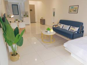 Rooftop Pool, Up to 8 Pax, 2 Bedrooms, 2 Bathrooms, 2 Car Parks by Star Home في جورج تاون: غرفة معيشة مع أريكة زرقاء وطاولة