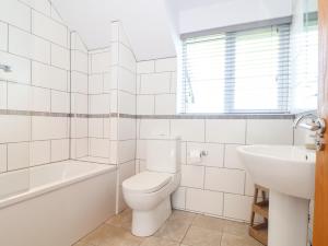 a white bathroom with a toilet and a sink at Charlotte's House in Penzance +28 photos