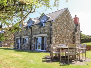 a stone house with a table and chairs in front of it at Charlotte's House in Penzance