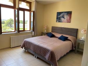 1 dormitorio con 1 cama con almohadas y ventanas azules en Apartments Villa Dinka, en Hvar