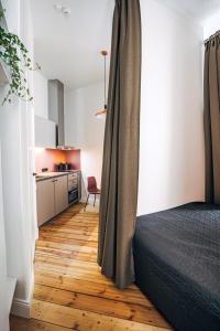 sypialnia z łóżkiem i drewnianą podłogą w obiekcie Constantine Apartments w Rydze