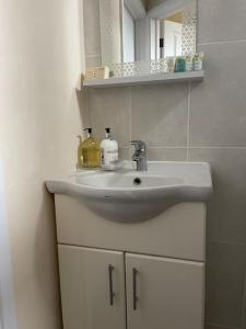 a bathroom sink with two bottles on top of it at Stunning 1 Bedroom Home in Southend-on-Sea