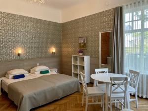 Schlafzimmer mit einem Bett, einem Tisch und Stühlen in der Unterkunft Green Villa in Pärnu