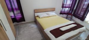 a bedroom with a large bed with purple curtains at Къща Поморини Несебър in Nesebar