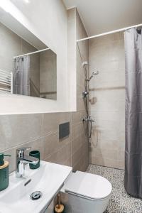 a bathroom with a shower and a toilet and a sink at Constantine Apartments in Rīga +78 photos