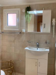 a bathroom with a white sink and a mirror at EY House in Halikounas