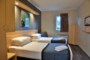 Habitación de hotel con 2 camas y ventana en Road Lodge Rivonia en Johannesburgo