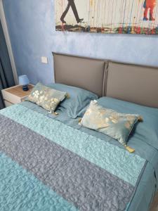 een slaapkamer met een bed met blauwe lakens en kussens bij B&B DIANA in Pordenone