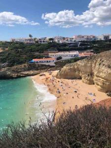 un grupo de personas en una playa cerca del agua en Quinta campò chalet en Alcantarilha