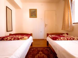2 camas en una habitación con ventana y alfombra en Balkan House, en Mostar