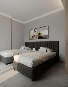 two beds in a room with white walls at Perle Apart Hotel in Alanya