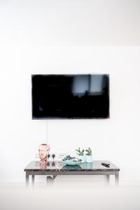 a table with a tv on a white wall at Bv Charming Studio with Free Private Parking, 10 Minutes from Town Centre in Leeds