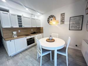 a kitchen and dining room with a table and chairs at Kolorowe Balkony by Baltic Home in Międzyzdroje