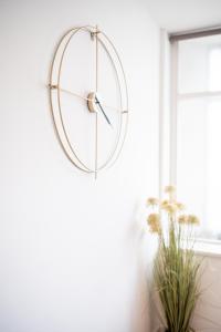 a clock hanging on a wall next to a window at Bv Charming Studio with Free Private Parking, 10 Minutes from Town Centre in Leeds