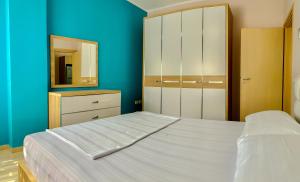 sypialnia z białym łóżkiem i lustrem w obiekcie Endy Apartaments w mieście Orikum