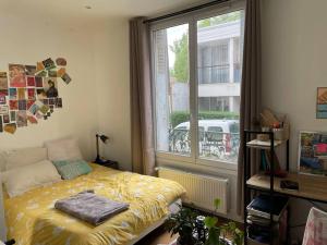 a bedroom with a bed in front of a window at Maison 6 chambres Paris in Villejuif