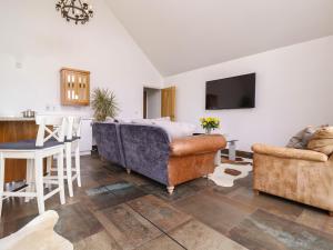 a living room with two couches and a kitchen at Polly's Annexe in Ipswich