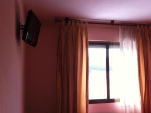 a room with a window and a television on a wall at Hostal Tio Pepe I in Bembibre