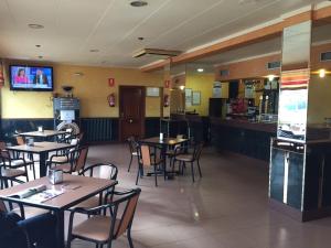 a restaurant with tables and chairs and a bar at Hostal Tio Pepe I in Bembibre