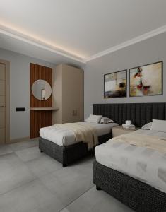 um quarto de hotel com duas camas e um espelho em Perle Apart Hotel em Alanya