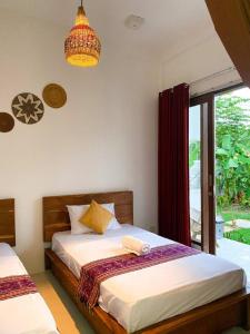 1 Schlafzimmer mit 2 Betten, einem Fenster und einem Kronleuchter in der Unterkunft The Hill View Lombok in Kuta Lombok