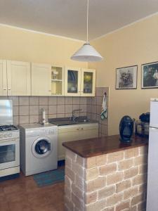 a kitchen with a washing machine and a washer at Casa Maris Stella in Platamona