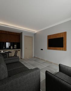 Il comprend un salon avec des canapés et une télévision à écran plat. dans l'établissement Perle Apart Hotel, à Alanya