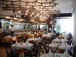 a dining room with white tables and chairs and people at Depadansa Marina & Primorka in Omišalj