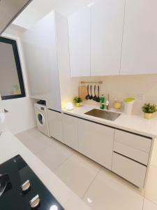 Rooftop Pool, Up to 8 Pax, 2 Bedrooms, 2 Bathrooms, 2 Car Parks by Star Home في جورج تاون: مطبخ أبيض مع حوض وميكروويف