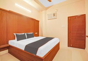 een slaapkamer met een groot bed met een houten hoofdeinde bij Hotel Aqua Villa Near Netaji Subhash Chandra Bose in Gauripur