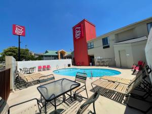 a swimming pool with chairs and a hotel at Red Roof Inn Branson in Branson