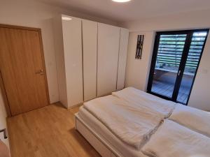 a bedroom with a bed and a large window at Quiet 1-bedroom in a basement of new villa in Prague