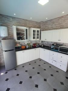 a kitchen with white cabinets and a tile floor at la sublime in Taghazout