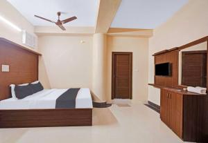 Hotel Aqua Villa Near Netaji Subhash Chandra Bose في Gauripur: غرفة نوم بسرير ومروحة سقف