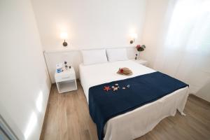 een slaapkamer met een groot wit bed en een blauwe deken bij Appartamento Iremar C1 - MyHo Casa in Vieste