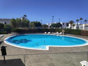 a large blue swimming pool in a courtyard at Fwt Relax Bungalow in Playa de las Americas