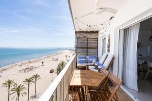 a balcony with a table and chairs and the beach at El Acuario - Primera línea y todas las ventanas dan al mar in Cullera