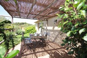 a table and chairs under a pergola in a garden at Auberge U Sirenu in Sartène