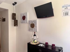 a room with a tv and a table with wine glasses at Hostal Nomadas in Cuenca +54 photos