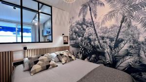 sypialnia z łóżkiem z malowidłem palmowym w obiekcie En plein centre de cannes à 2 pas de la croisette w Cannes