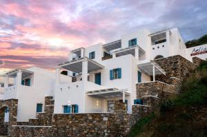 a white building on a hill with a sunset at Aelia Studios in Aegiali
