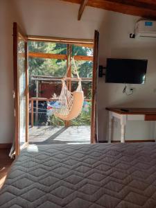a bedroom with a hammock and a sliding glass door at Cabaña en la Colina in Sierra de los Padres
