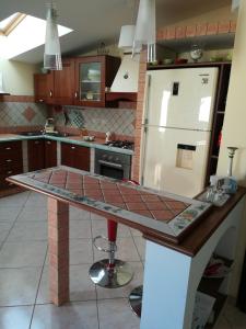 a kitchen with a counter and a white refrigerator at Casa Carmelo in Nizza di Sicilia