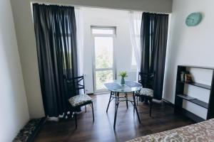a room with a table and chairs and a window at Apartments біля ЖД вокзалу in Ivano-Frankivsʼk